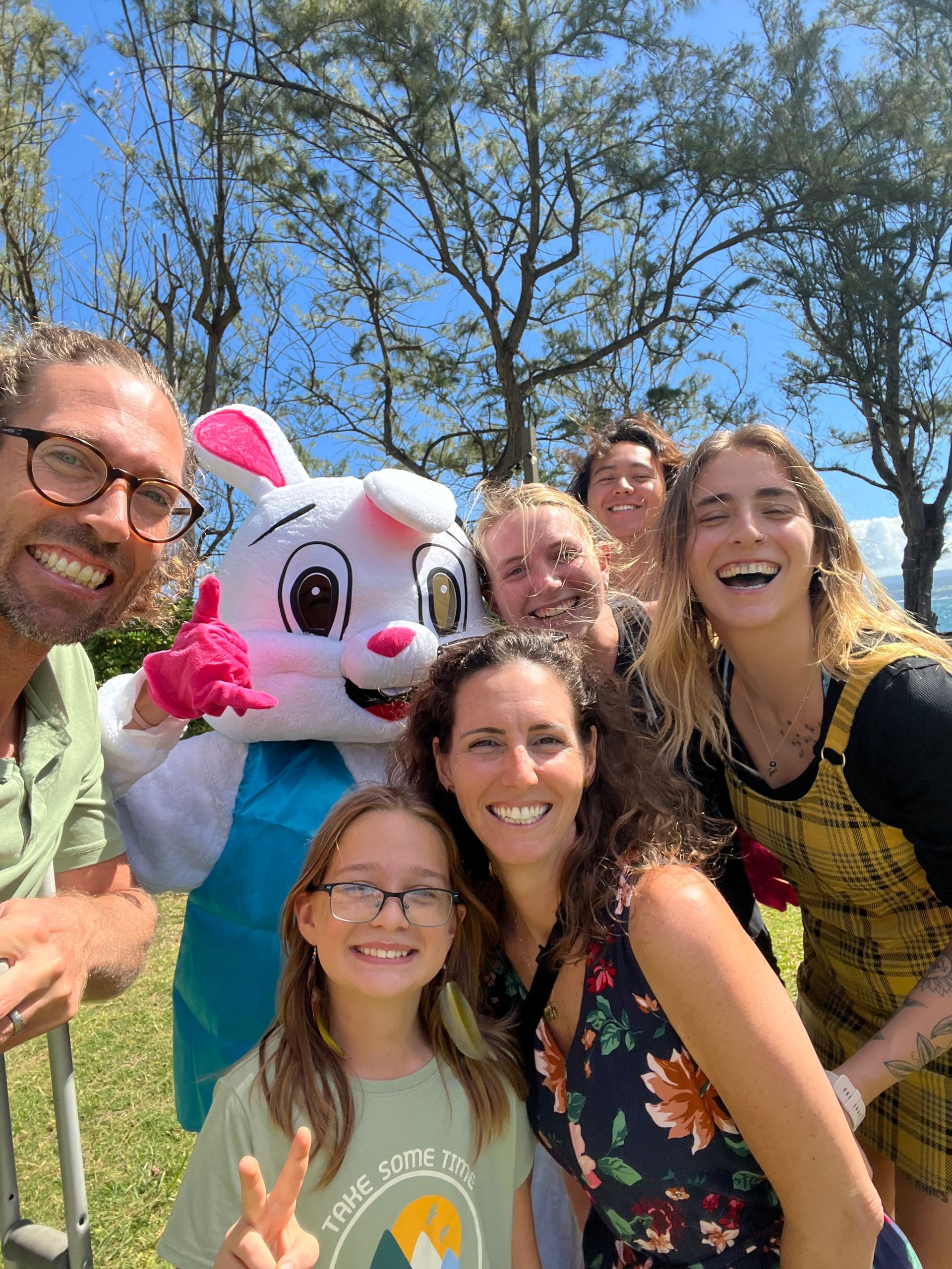 A group of people are posing for a picture with a bunny mascot.