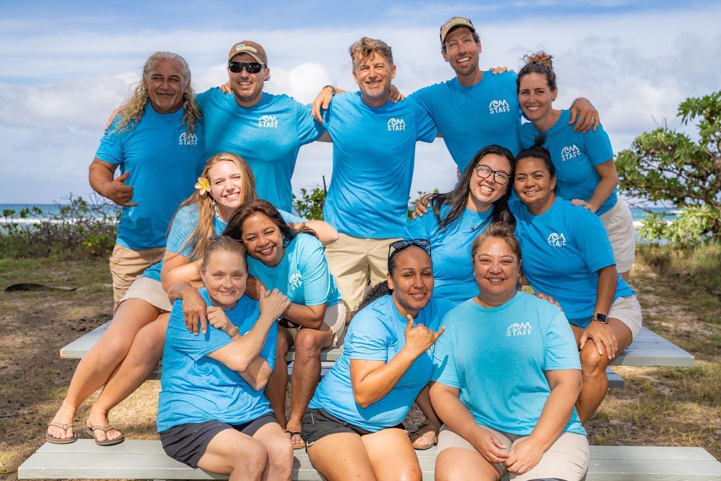 A group of people wearing blue shirts are posing for a picture.