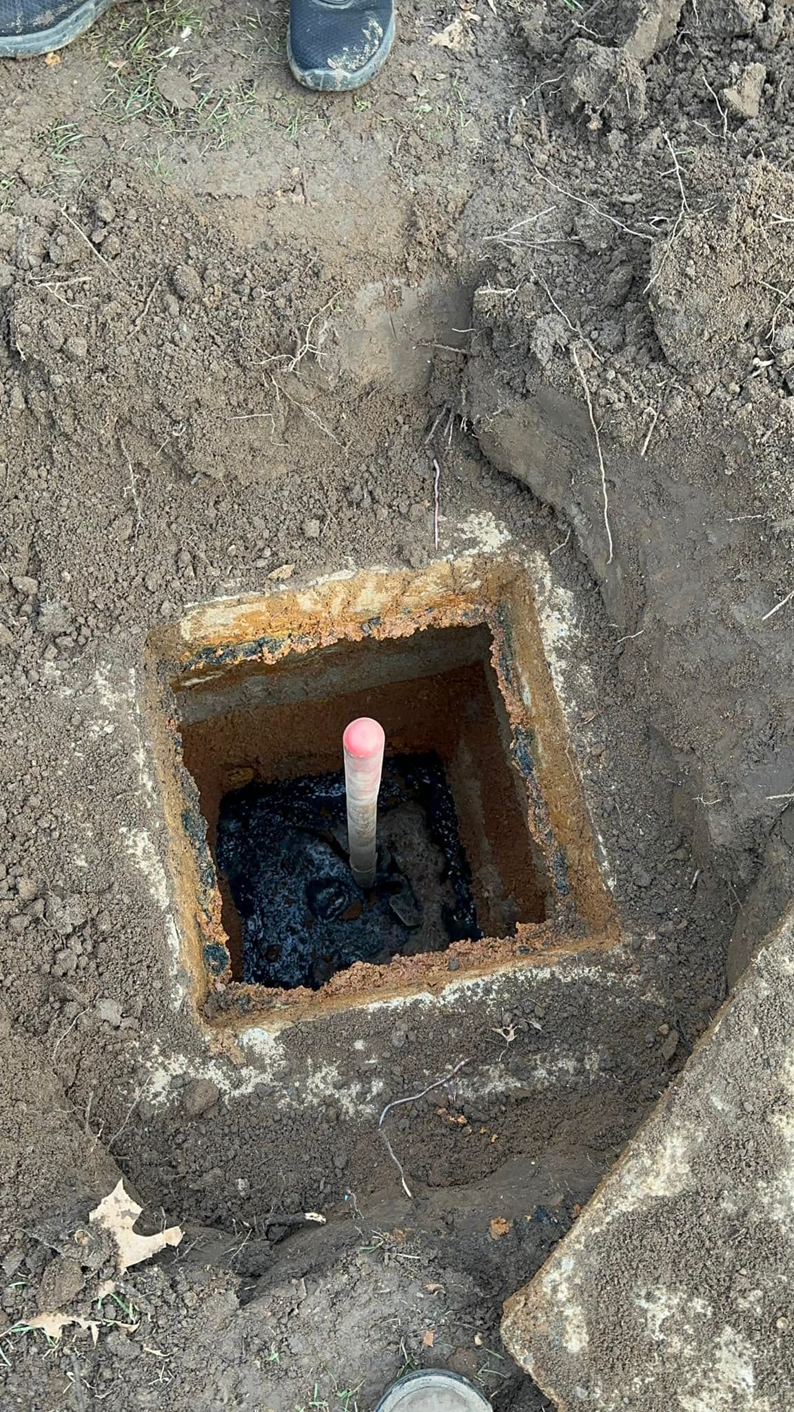 A pipe is sticking out of a hole in the ground.