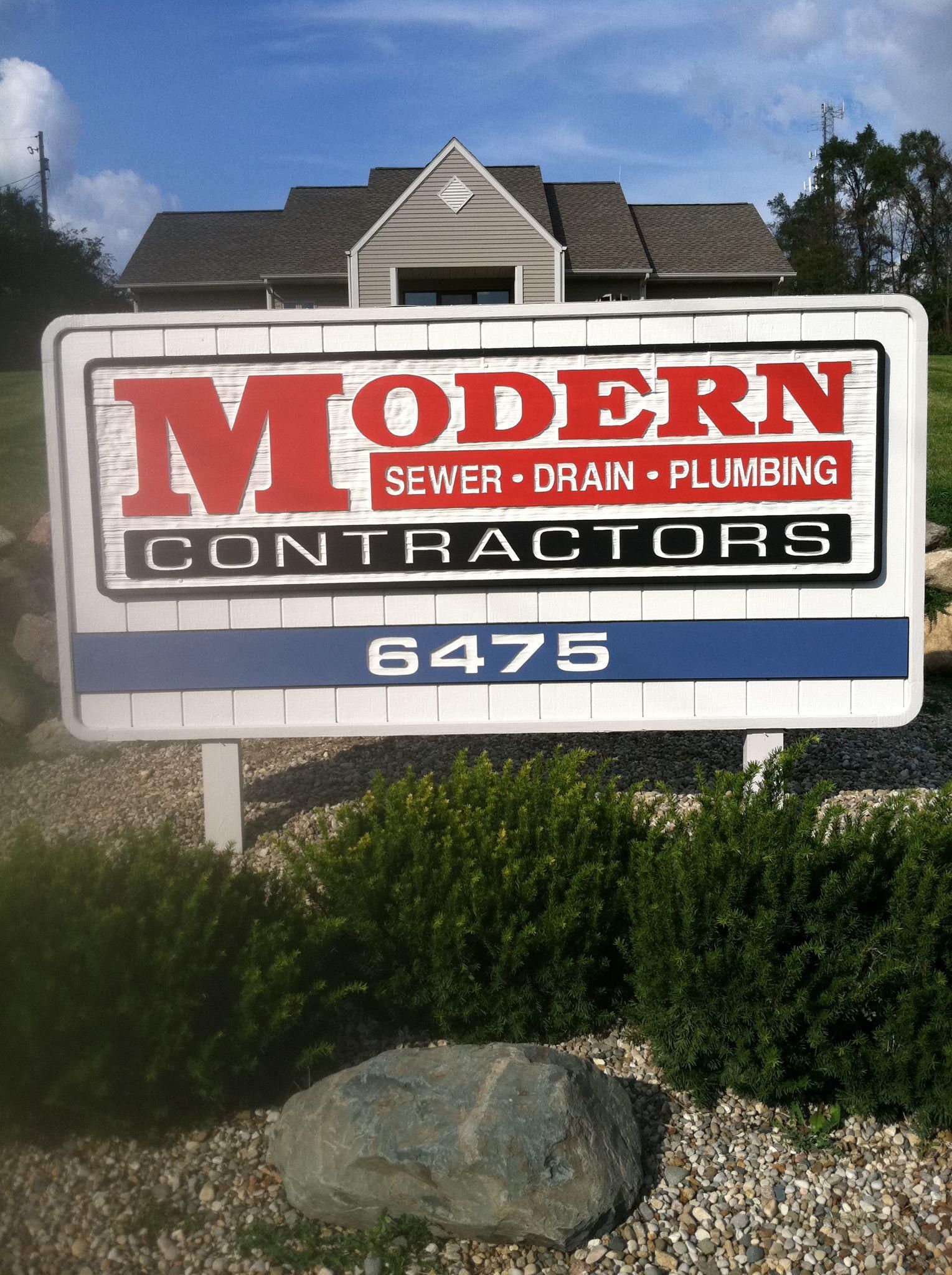 A modern contractors sign in front of a house