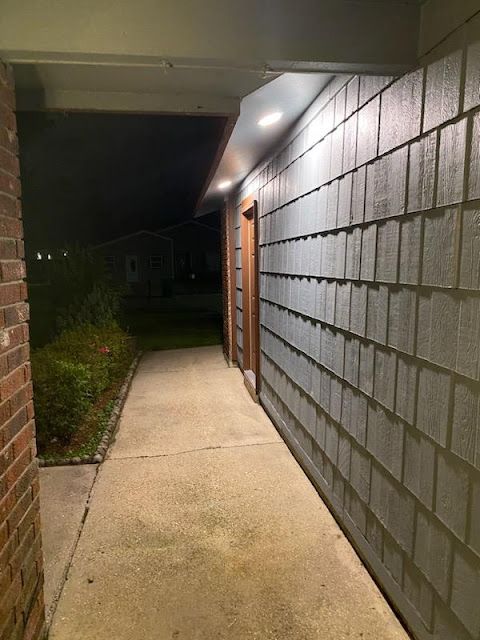 A walkway between two brick buildings at night
