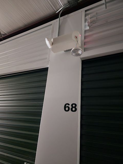 A light on the side of a building with the number 68 on it.