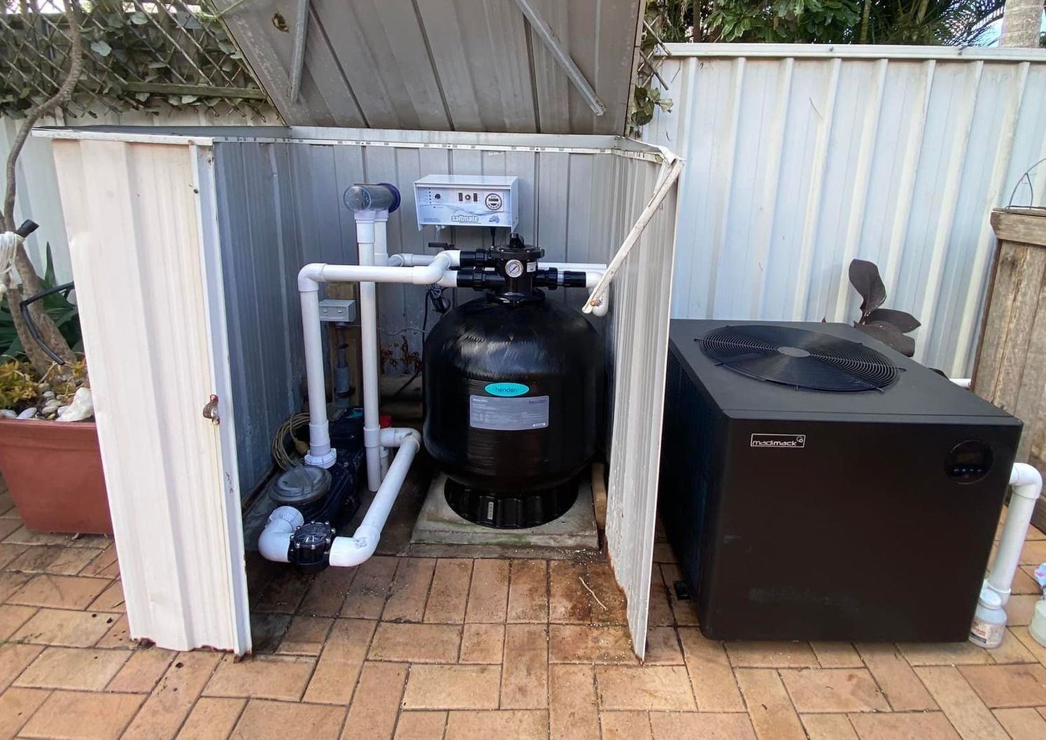 Pool equipment enclosure: Filter, pump, and heater on a brick patio — Tempshift Pool Heating in Buff Point, NSW