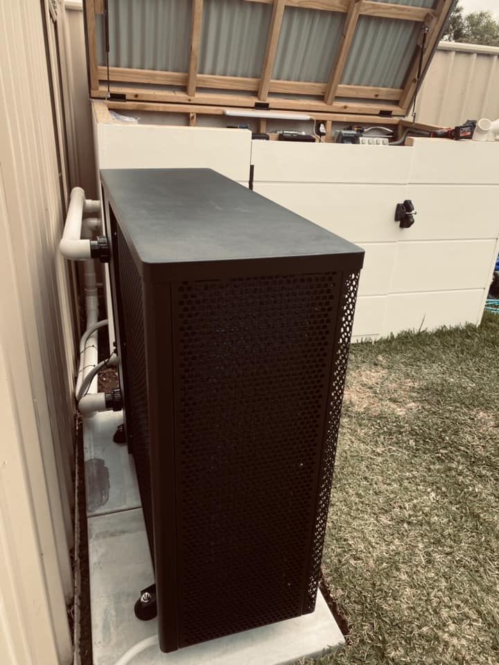 A Dark-Coloured Pool Heater is Outdoors Against a Wall — Tempshift Pool Heating in Buff Point, NSW
