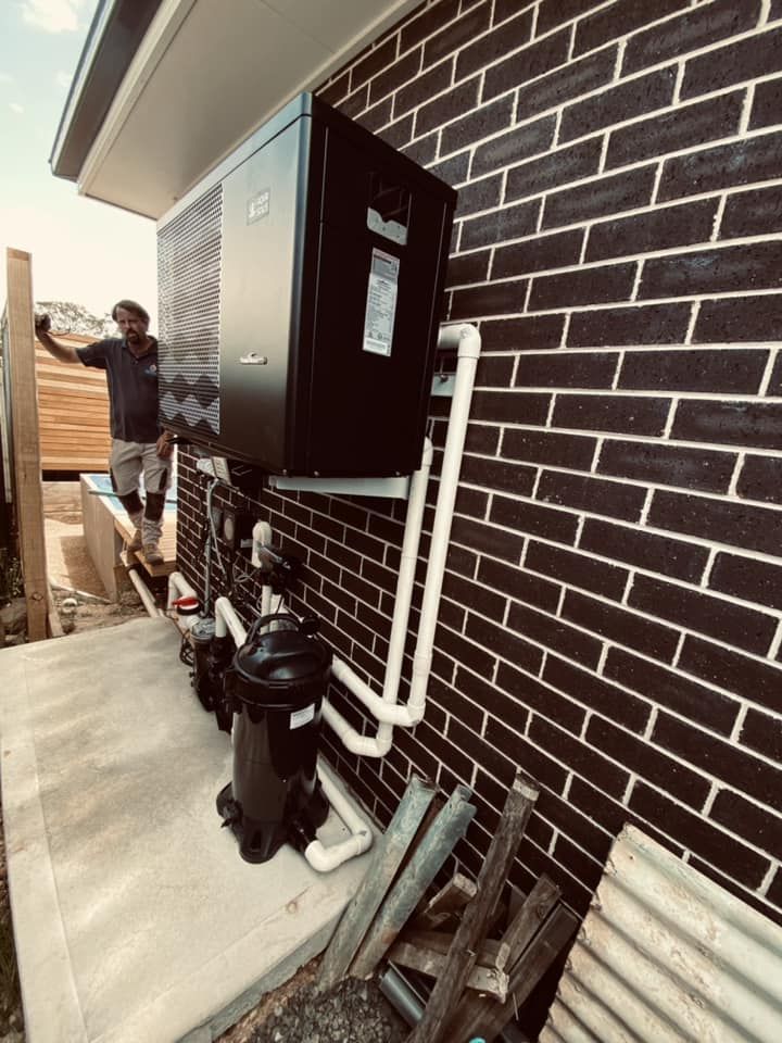 Black Heat Pump on Brick Wall — Tempshift Pool Heating in Gosford, NSW