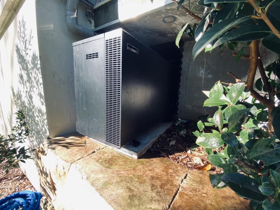 A Dark-Coloured Pool Equipment is Sitting on a Concrete Base — Tempshift Pool Heating in Buff Point, NSW