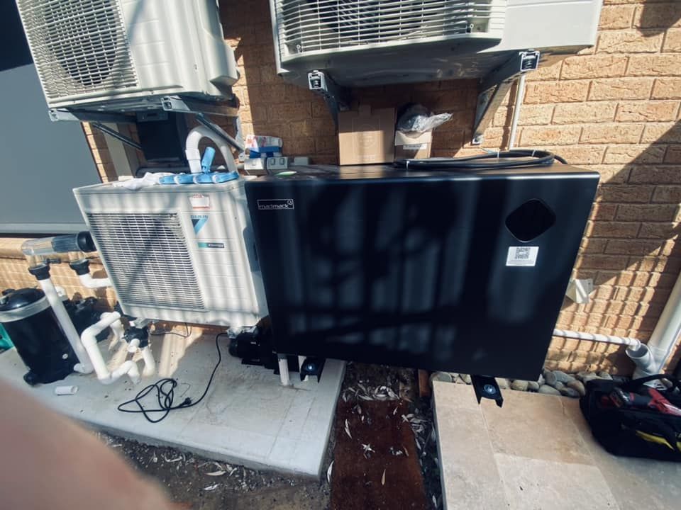 Black Pool Heater, and Piping Attached to a Brick Wall — Tempshift Pool Heating in Lake Macquarie, NSW