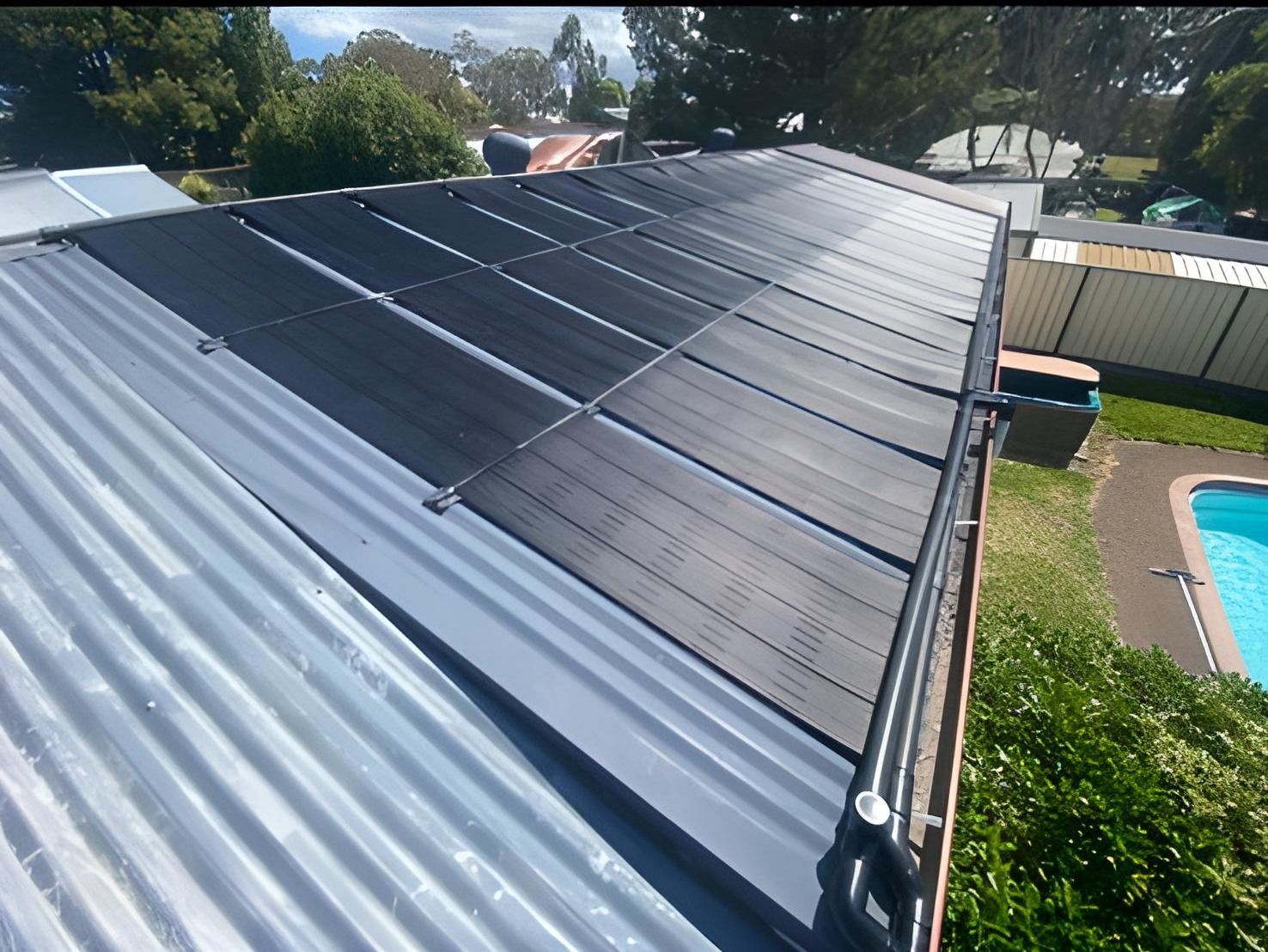 Solar Panels Installed on a Corrugated Metal Roof, Adjacent to a Pool and Yard — Tempshift Pool Heating in Buff Point, NSW