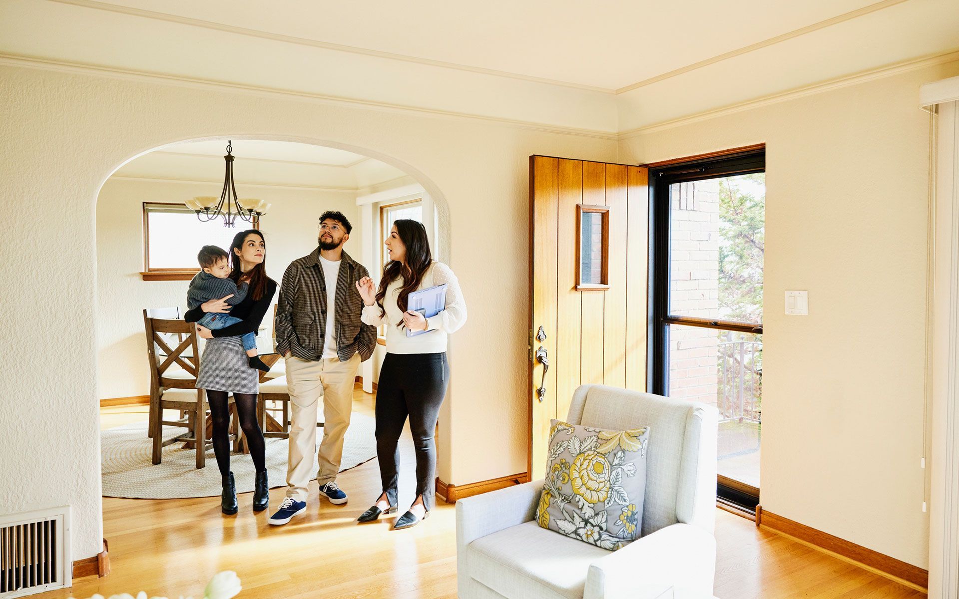 A family is standing in a living room looking at a house.