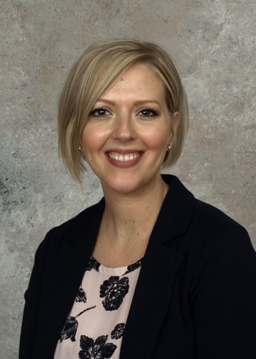 A man in a suit and white shirt is smiling for the camera.