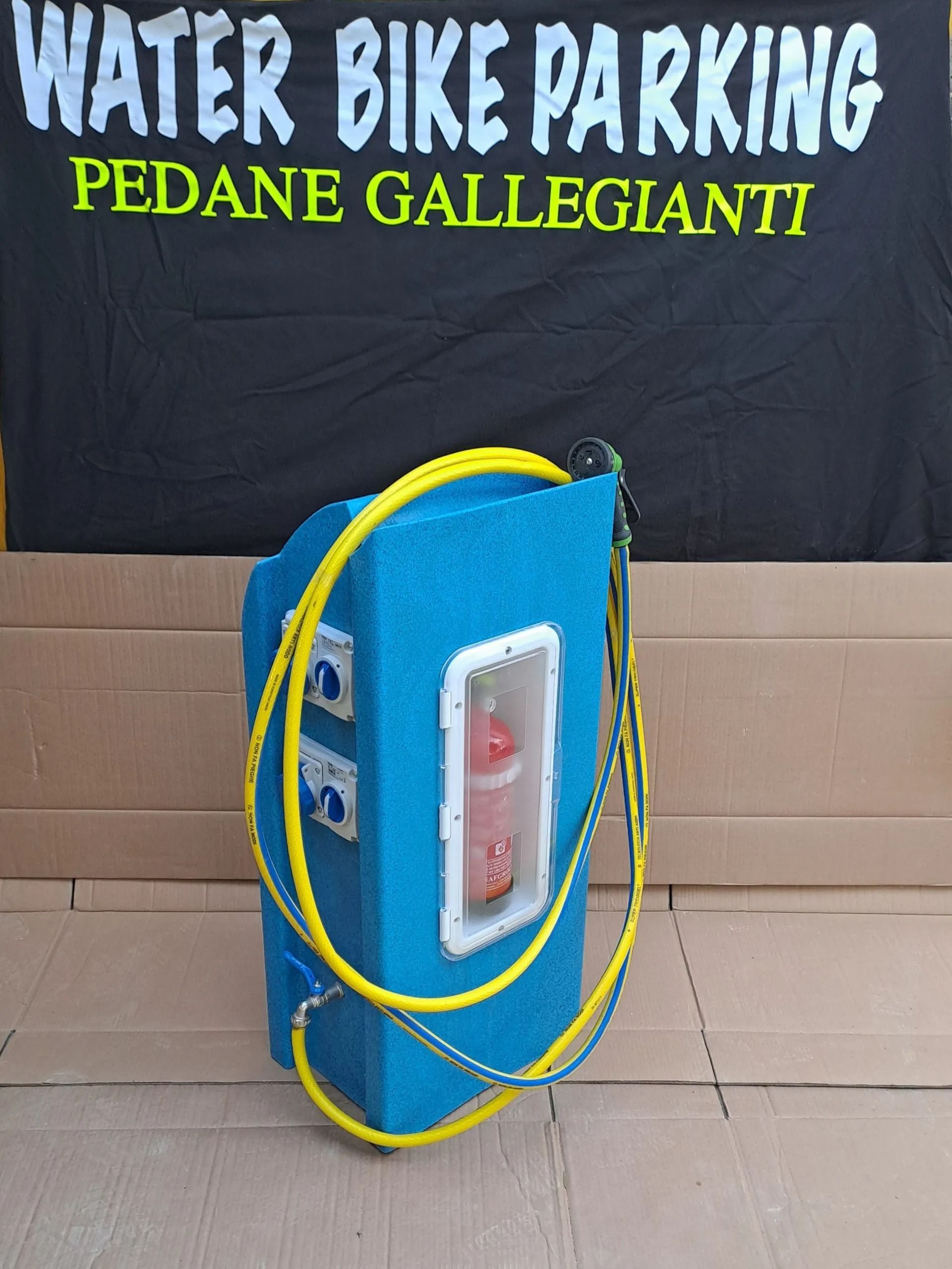 Stazione di parcheggio blu per biciclette acquatiche con corda gialla, su cartone. Cartello: Parcheggio biciclette acquatiche.