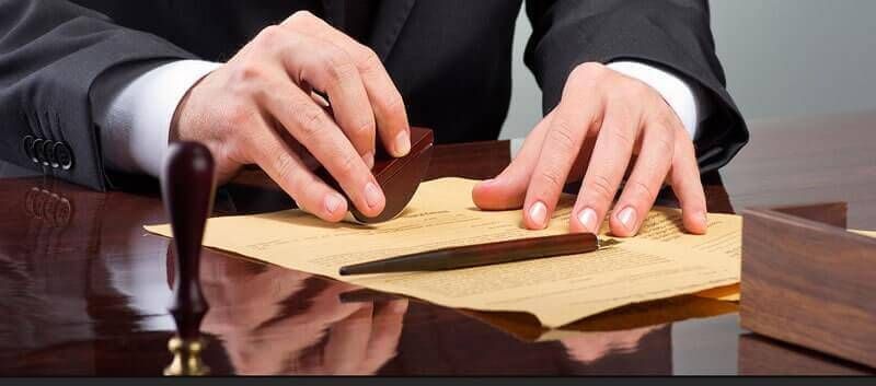 Un hombre con traje está estampando un trozo de papel.