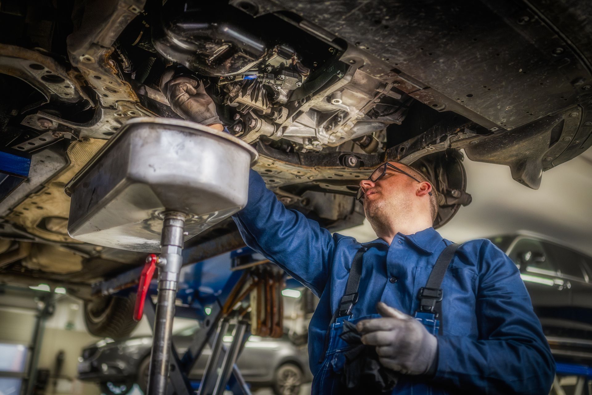 Car mechanic performing an oil change on a modern vehicle Car mechanic performing an oil change on a modern vehicle