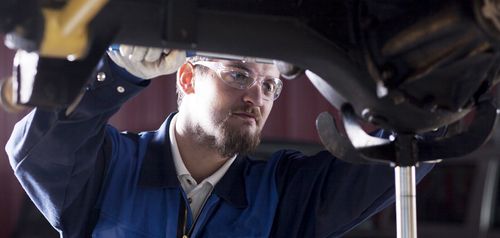 Mechanic performing auto brake repair services in Anchorage, AK