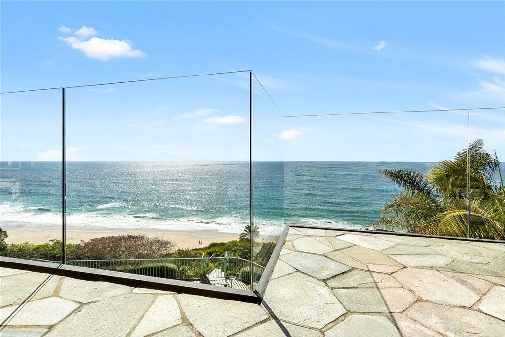 A view of the ocean from a balcony with a glass fence.