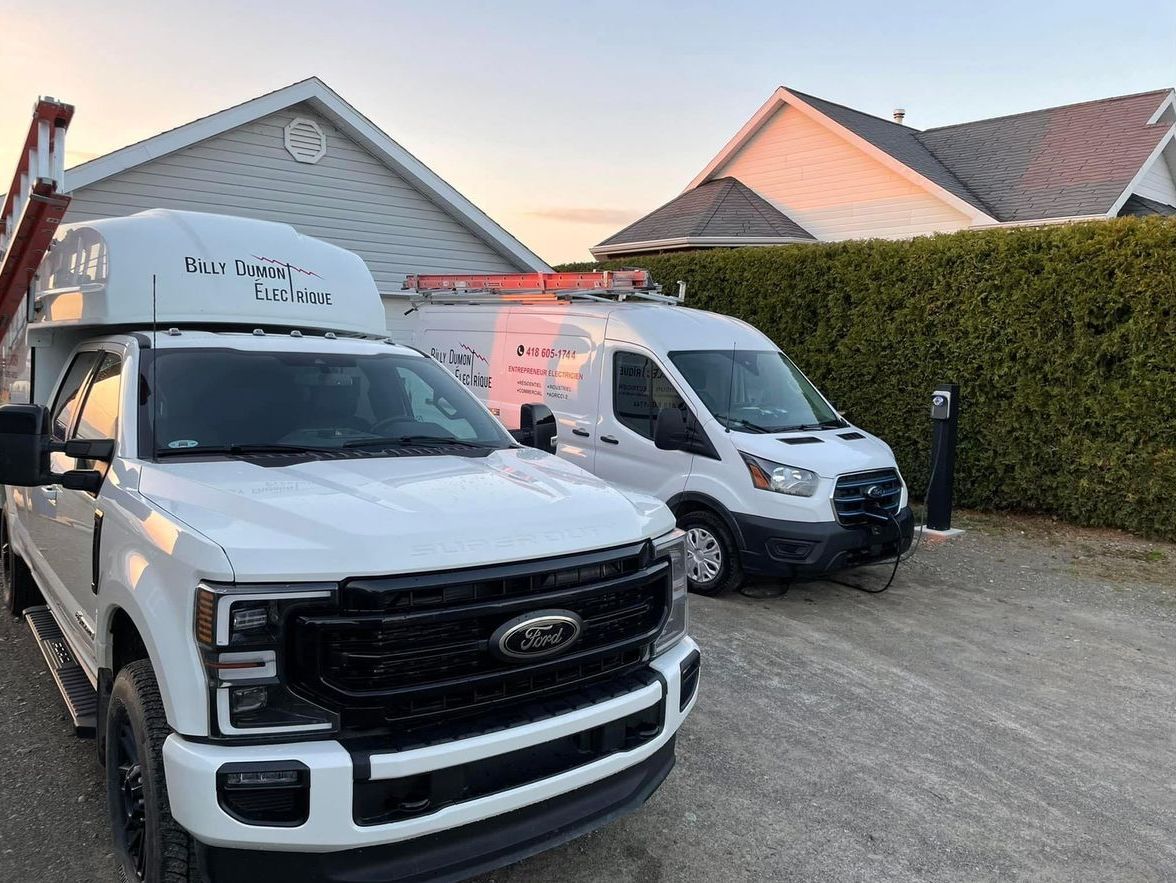 Deux camions blancs sont garés devant une maison.