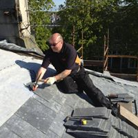 roofer installing a new roof on a residential building