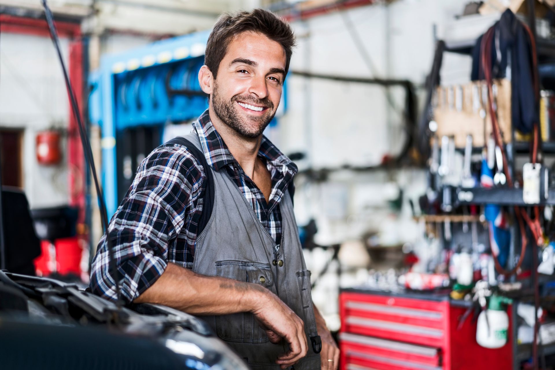 A confident mechanic at an auto repair shop. A confident mechanic at an auto repair shop.
