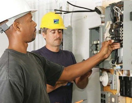 Engineers inspecting electrical panel