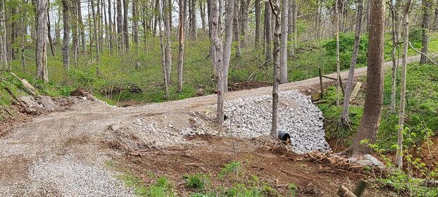 Dirt road in the middle of a forest with trees and rocks on both sides - Campbellsburg, IN | Twisted Electric LLC 
