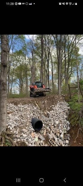 Bulldozer driving through a pile of rocks with black pipe underneath - Campbellsburg, IN | Twisted Electric LLC 