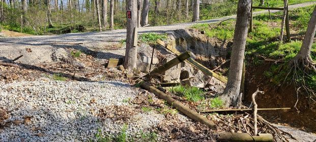 Broken wooden fence sitting next to a gravel road in the woods - Campbellsburg, IN | Twisted Electric LLC 