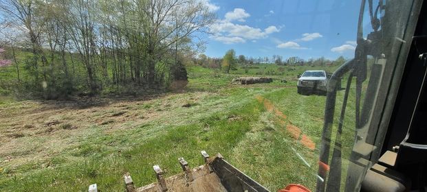 White truck parked in the grass next to a bulldozer in a field with bucket - Campbellsburg, IN | Twisted Electric LLC 