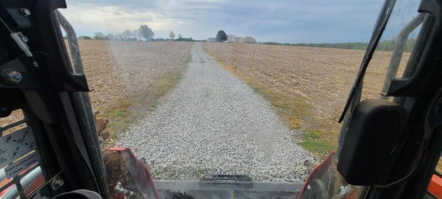 Tractor driving down a gravel road next to a dry grass field - Campbellsburg, IN | Twisted Electric LLC 