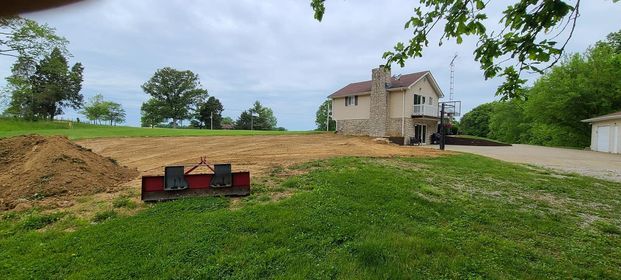 Large house sitting on top of a lush green hillside with red metal - Campbellsburg, IN | Twisted Electric LLC 