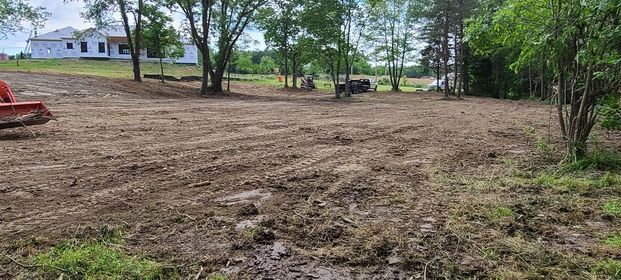 Large dirt field with a house and orange item in the background - Campbellsburg, IN | Twisted Electric LLC 