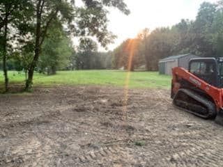 Bulldozer parked in the middle of a dirt field with sun ray - Campbellsburg, IN | Twisted Electric LLC 