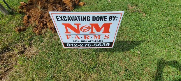 Sign that says excavating done by nom sitting on top of a lush green field - Campbellsburg, IN | Twisted Electric LLC 