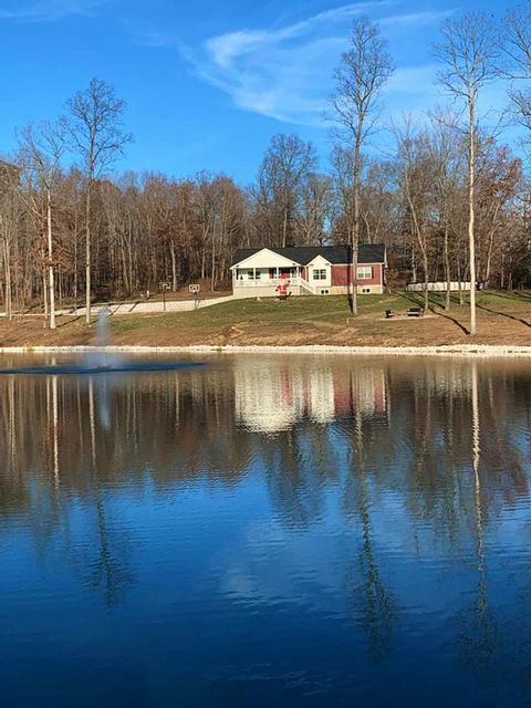 Far house sitting on the shore of a lake surrounded by trees - Campbellsburg, IN | Twisted Electric LLC 