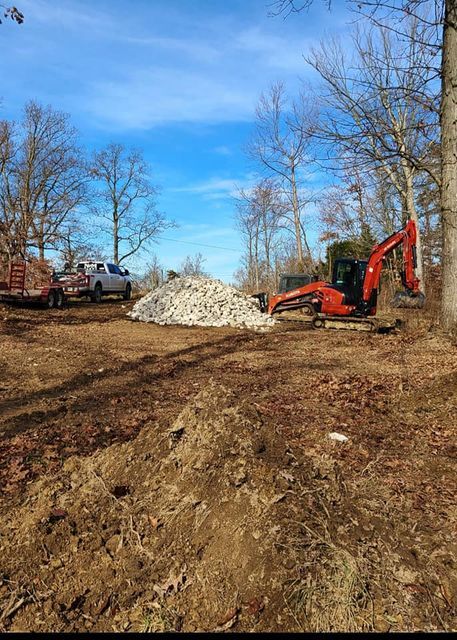 Excavator moving a pile of rocks in a dirt field on the afternoon - Campbellsburg, IN | Twisted Electric LLC 
