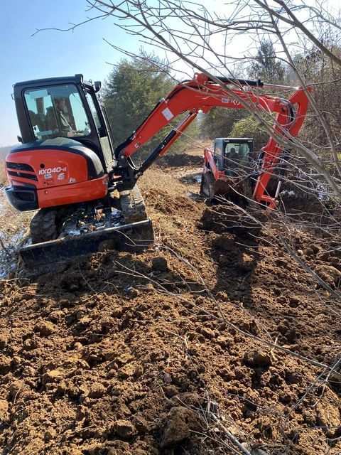 Red and black excavator digging a hole on a steep dirt - Campbellsburg, IN | Twisted Electric LLC 