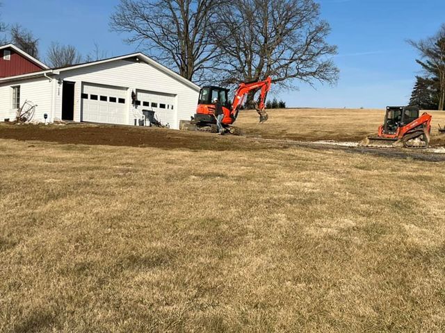 Couple of red tractors working in a field in front of a house - Campbellsburg, IN | Twisted Electric LLC 