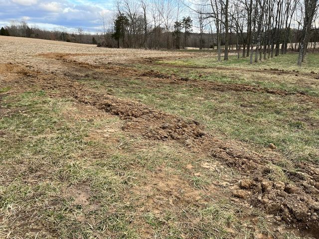 Muddy field with a lot of dirt and trees in the background - Campbellsburg, IN | Twisted Electric LLC 