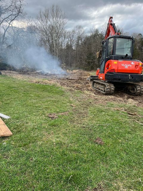 Red excavator moving dirt in a field with smoke coming out of it - Campbellsburg, IN | Twisted Electric LLC 