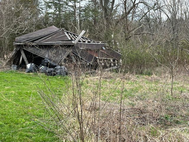 Old shed sitting in the middle of a grassy field surrounded by trees - Campbellsburg, IN | Twisted Electric LLC 