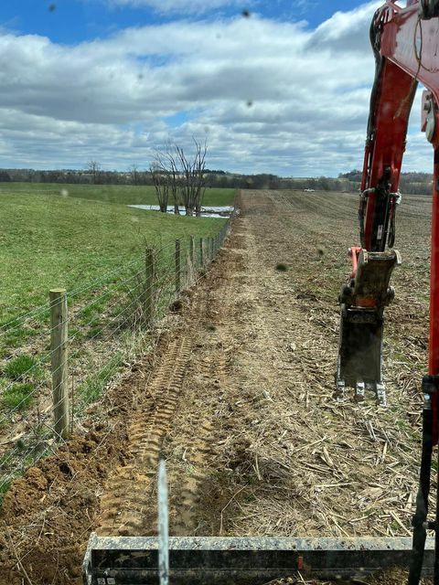 Red excavator working on a wide dirt road next to a field - Campbellsburg, IN | Twisted Electric LLC 