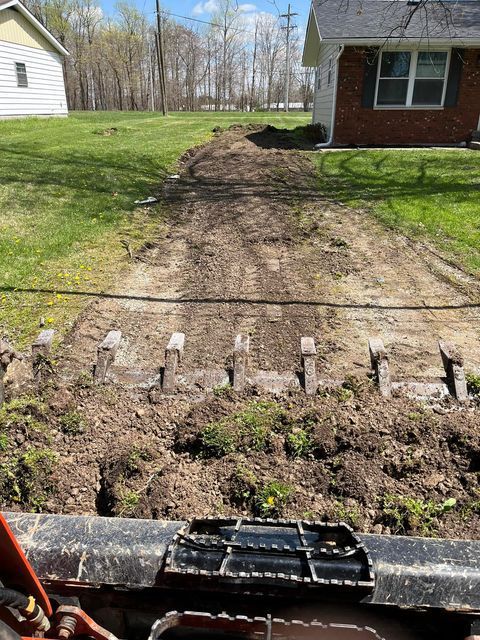 Bulldozer digging a dirt road in front of a brick house - Campbellsburg, IN | Twisted Electric LLC 