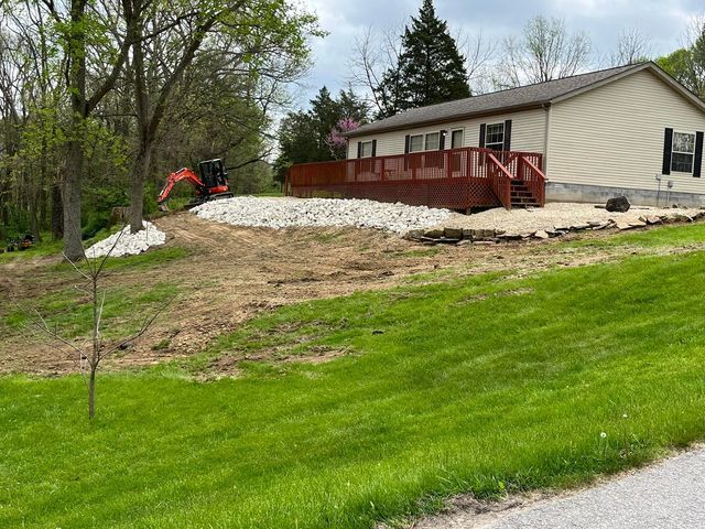 House with a red deck and a small excavator in front of it  - Campbellsburg, IN | Twisted Electric LLC 