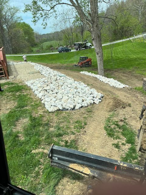 Tractor driving down a dirt road with man and trucks behind - Campbellsburg, IN | Twisted Electric LLC 