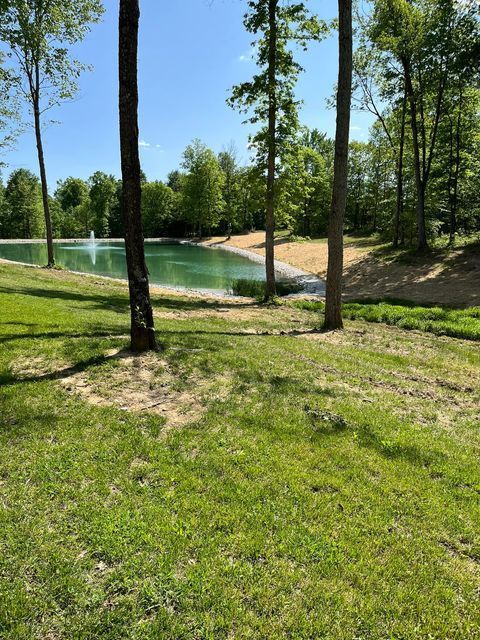 Large pond surrounded by trees and grass with a fountain in the middle - Campbellsburg, IN | Twisted Electric LLC 