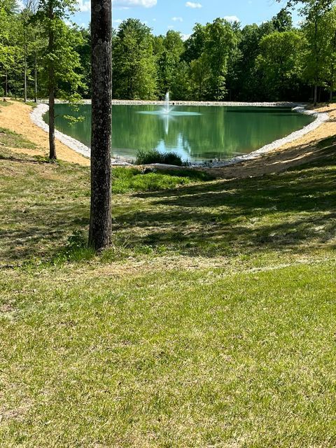 Large pond with a fountain in the middle of it surrounded by trees - Campbellsburg, IN | Twisted Electric LLC 