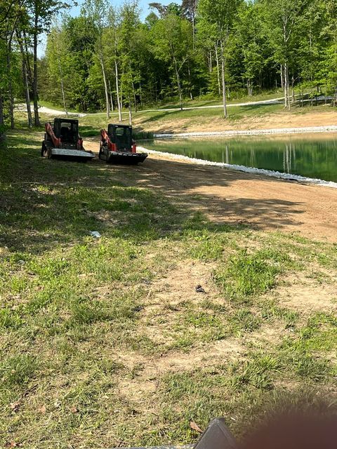 Couple of tractors are parked next to a lake - Campbellsburg, IN | Twisted Electric LLC 