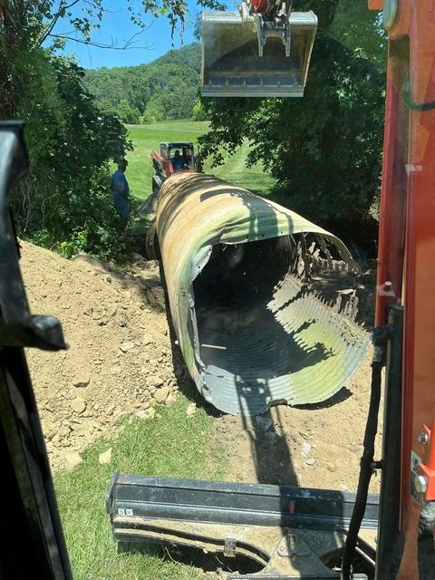 Large metal pipe being lifted out of the ground by a bulldozer - Campbellsburg, IN | Twisted Electric LLC 