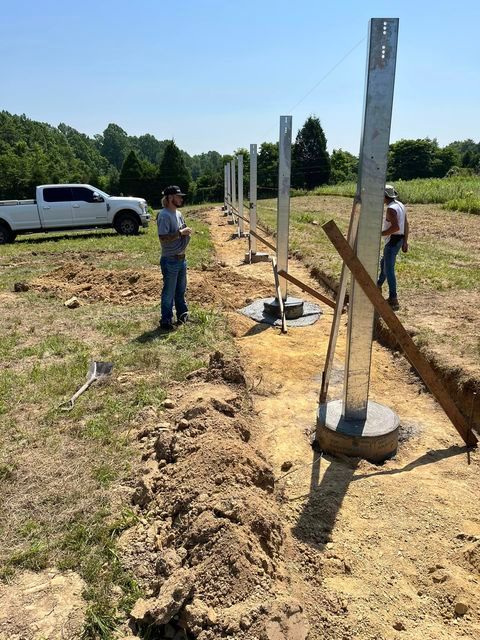 Man standing in the dirt next to a fence - Campbellsburg, IN | Twisted Electric LLC 