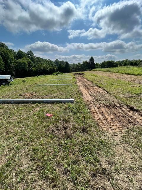 Dirt road going through a grassy field with long pipe - Campbellsburg, IN | Twisted Electric LLC 