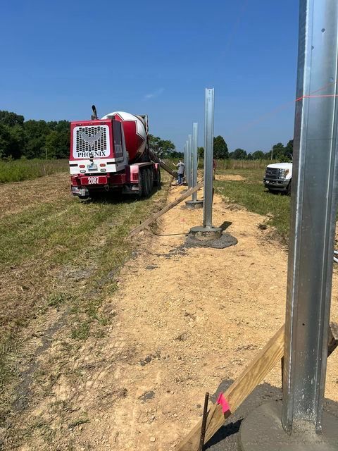 Red concrete mixer truck driving down a dirt road - Campbellsburg, IN | Twisted Electric LLC 